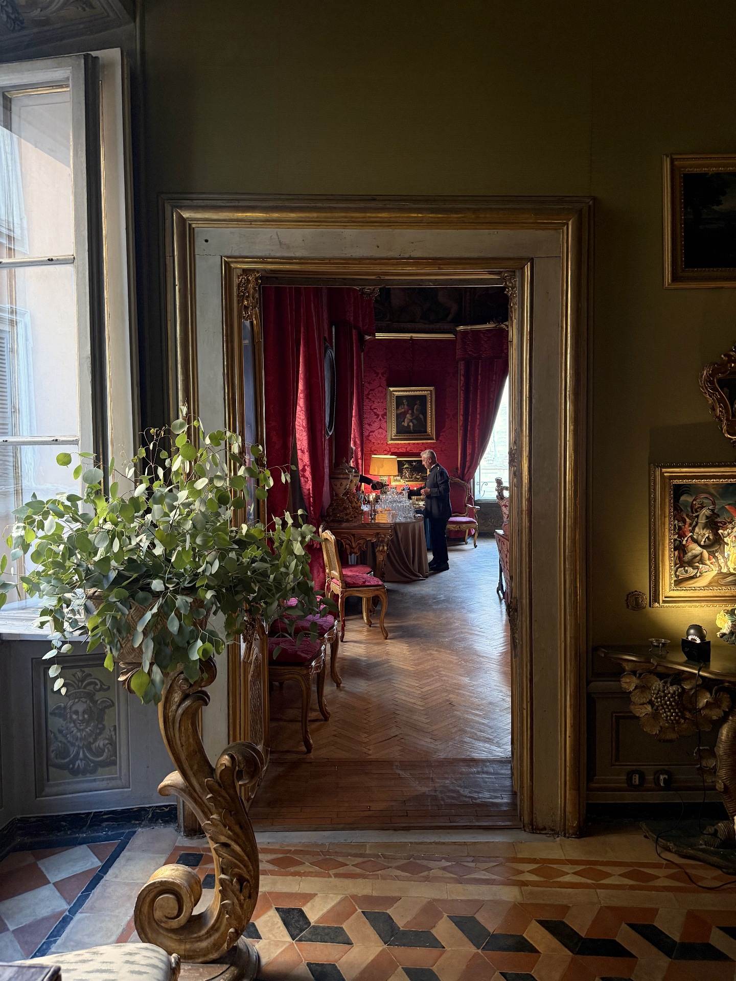 A view through the gilded doorway into the crimson salon