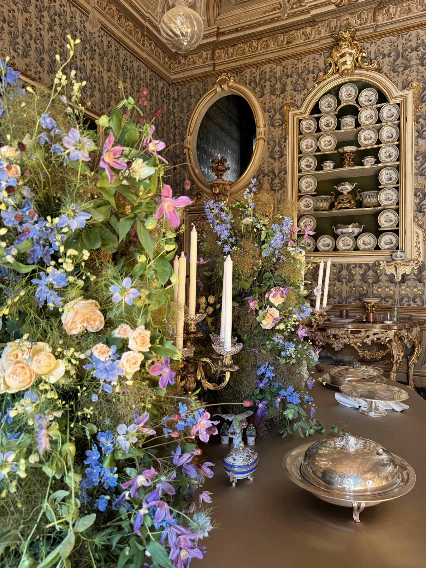 Porcelain cabinet and floral compositions in the mirror room